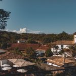 Vista de Tiradentes, em Minas Gerais, com construções coloniais sob céu azul.