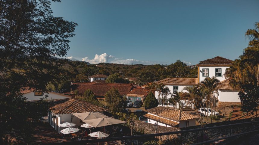 Vista de Tiradentes, em Minas Gerais, com construções coloniais sob céu azul.